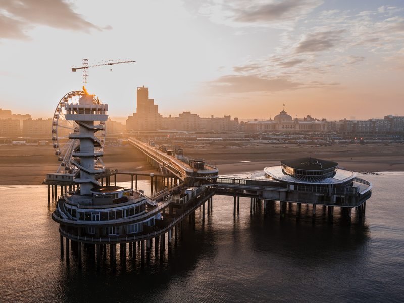 De Scheveningse pier aan zee bij zonsondergang